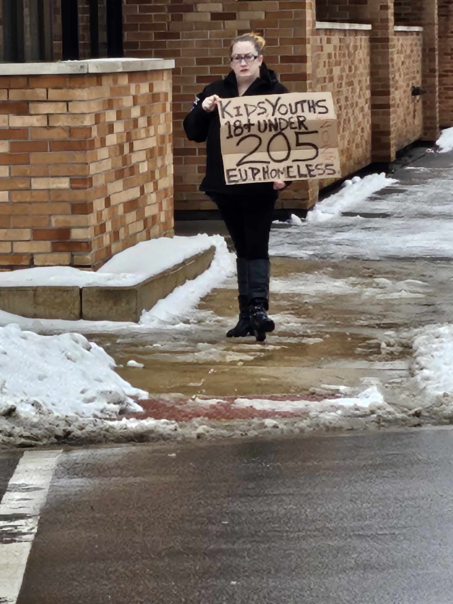 staff holding cardboard sign