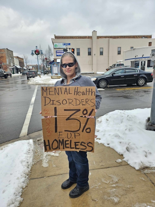 staff holding cardboard sign