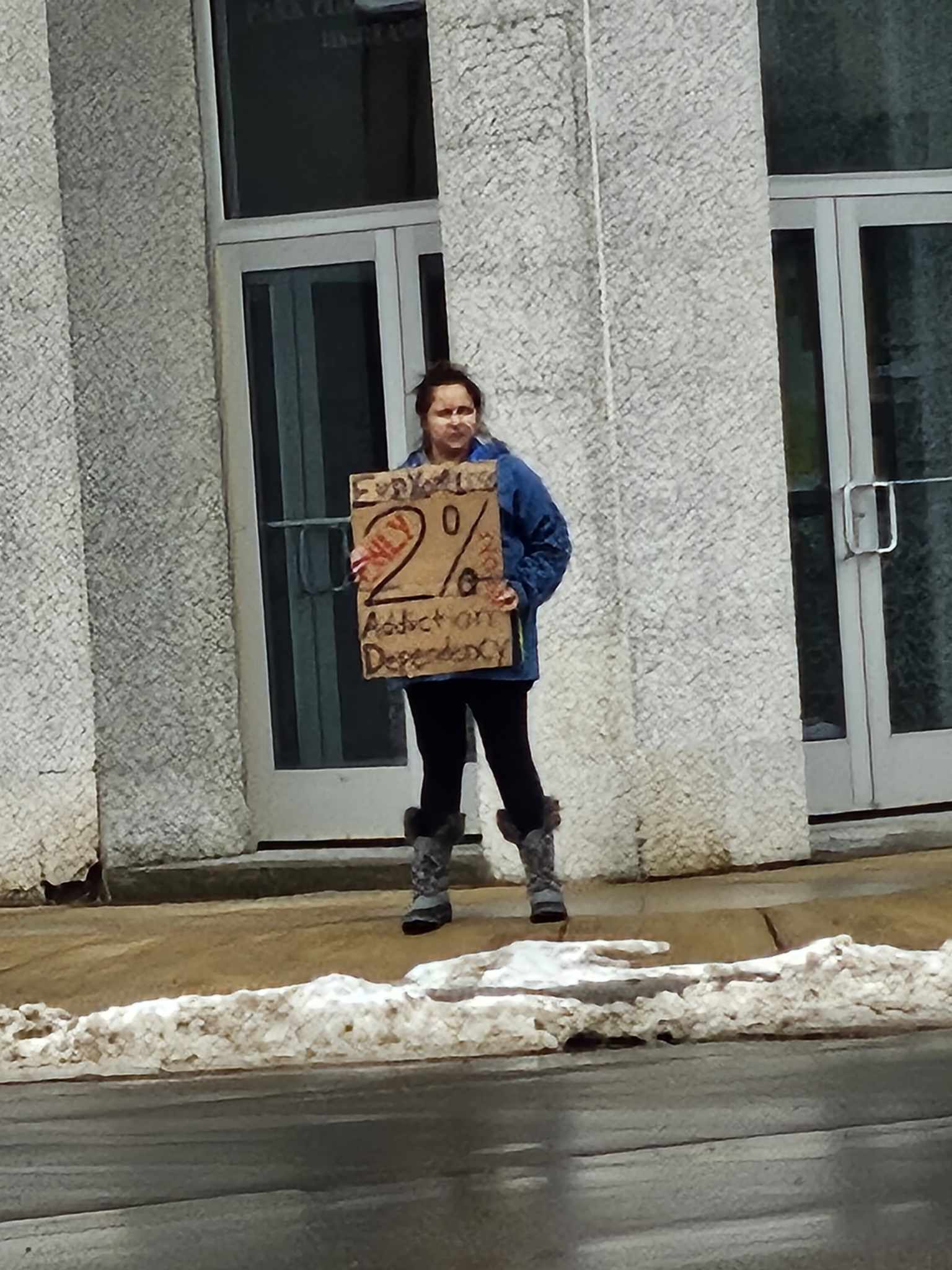 staff holding cardboard sign