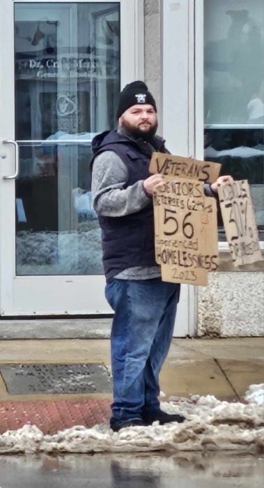 staff holding cardboard sign